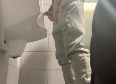 2 Boys in Sneakers Having Fun at Public Toilets' Urinal